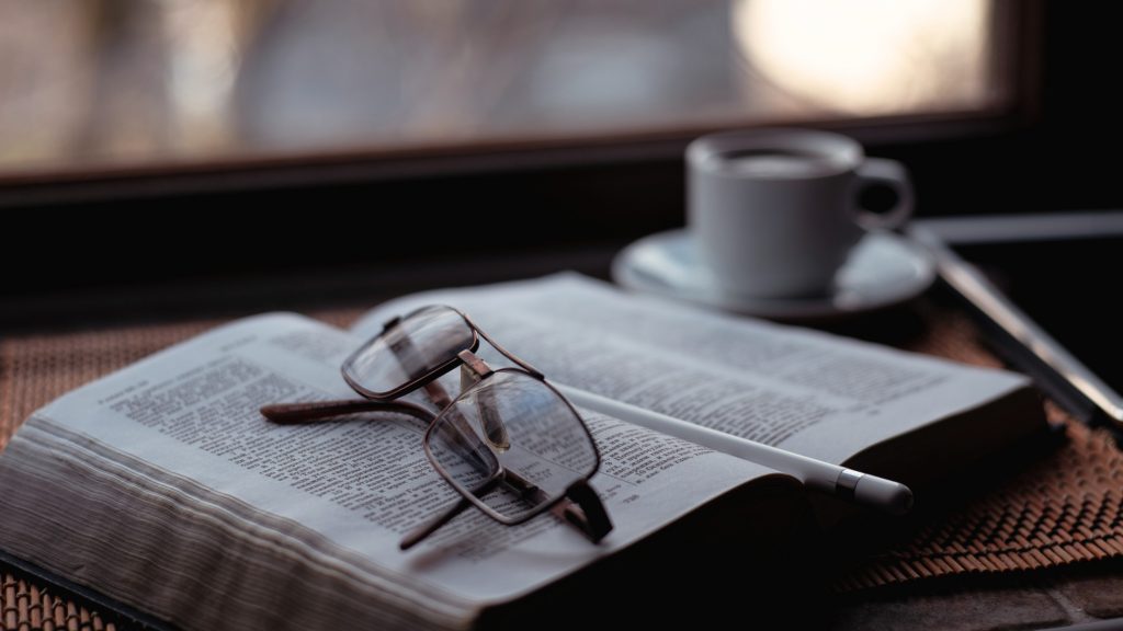 Bibel mit aufgelegter Brille und Kaffeetasse - Ruhe, Einkehr und Stille Zeit mit Gott